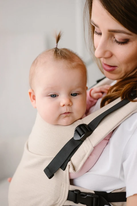 Modelka-nosi-dziecko-w-ergonomicznym-nosidle-KAVKA-multi-age-vanilla-twill----bezowe-nosidlo-z-bialym-wzorem-w-drobna-jodelke.---a-beige-carrier-with-a-white-twill-pattern (8).webp