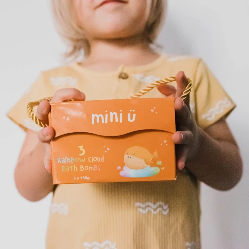 Teczowe-chmurki-do-kapieli-dla-dzieci-tworzace-kolorowy-wir-Mini-U-w-rekach-dziecka.webp